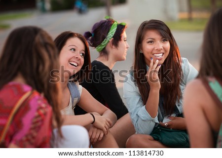 Interested female teenager in conversation with friends