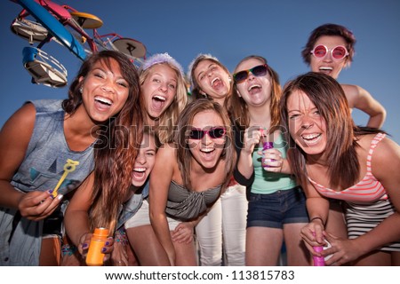 Group of happy girls with bubbles at amusement park