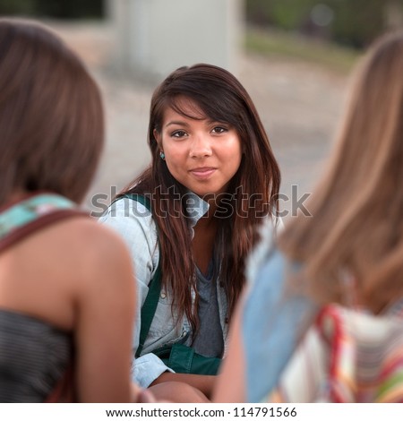 Calm young Native American teenager between two friends