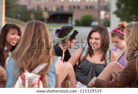 Young woman laughing with her friends sitting outside