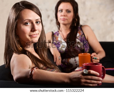 Beautiful grinning white woman with serious friend in background