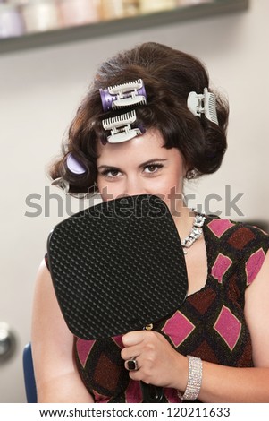 Insecure young white female in curlers behind mirror