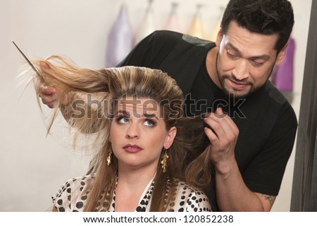 Embarrassed male hair stylist and female customer in salon