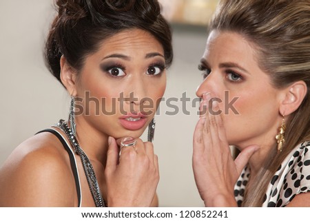 Concerned young woman listening to someone whispering secrets