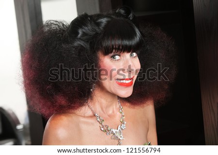 Excited Caucasian woman with afro haircut and big grin
