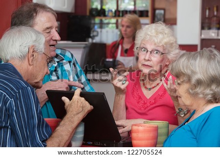Overwhelmed female adult senior with friends and laptop problem