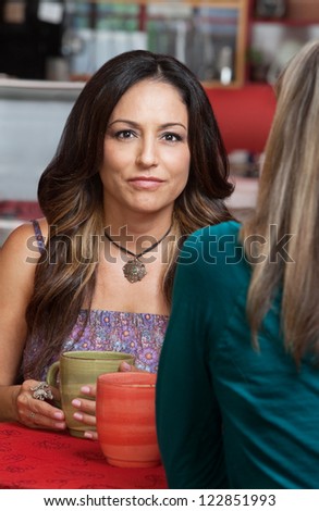 Beautiful Hispanic woman with friend in restaurant