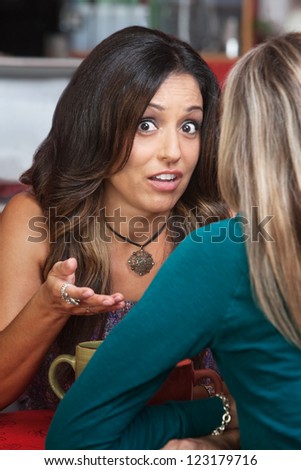 Serious woman gesturing with hands in conversation in restaurant