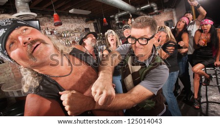 Brave geek with glasses punches biker gang man in bar