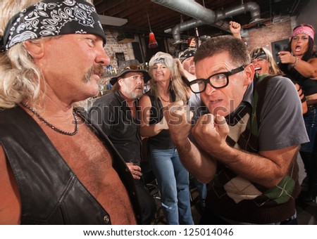 Nerd confronting tough gang member in leather vest in bar