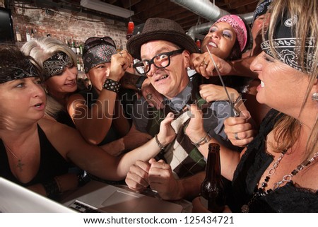 Nervous male nerd with group of intimidating biker gang women