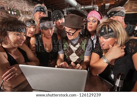 Group of impressed biker gang members watching nerd using a computer