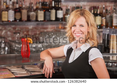 Pretty blond mature woman with arm on counter at bar