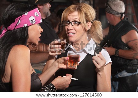 Blond woman and biker gang lady talking while smoking and drinking