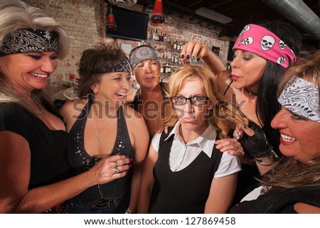Cruel gang of mature women teasing a nerd in a bar