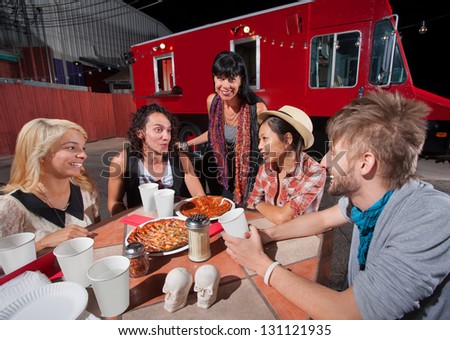 Five hipsters at mobile pizza restaurant with plates of food