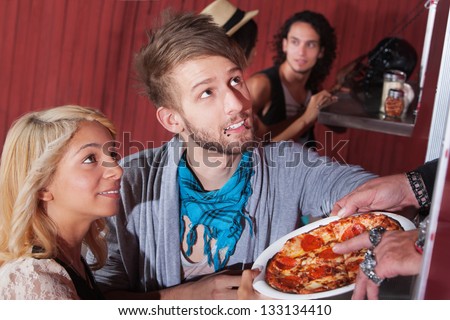 Cute boyfriend and girlfriend picking up pizza order