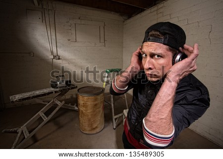 European hip hop guy with backwards cap and earphones