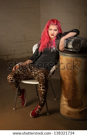 Indifferent Caucasian girl with pink hair and cd player