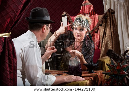 Fortune teller gesturing a gun to her head with customer