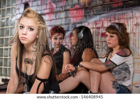 Girls ignoring sad blond young woman outside
