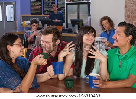 Four happy friends talking in a coffee house