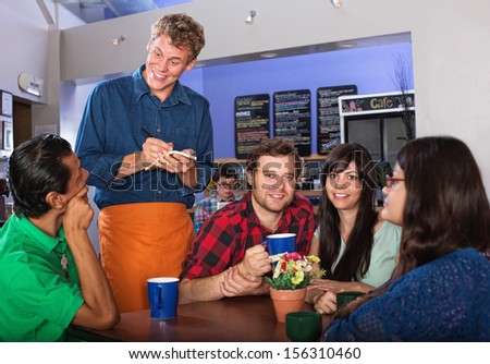 Young people ordering from attendant in a coffee house
