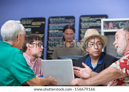 Man gesturing while talking with friends in cafe