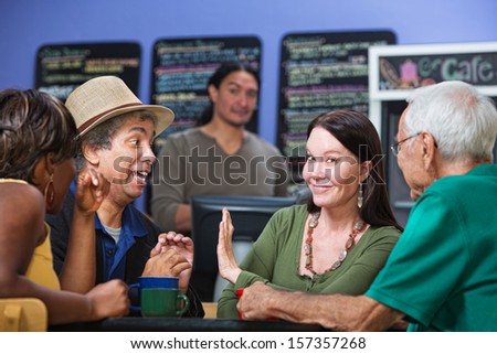 Woman gesturing man in cafe to stop talking