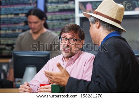 Pair of men talking in a cafe