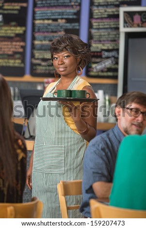 Gorgeous barista in apron working in coffee house