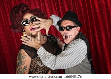 Surprised drag queen and partner in sunglasses