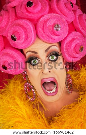 Screaming drag queen with pink foam wig in theater