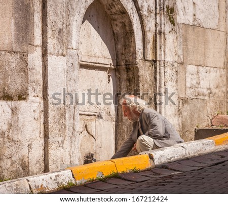ISTANBUL, TURKEY APRIL 28: Galata neighborhood man in Istanbul filling a water bottle at a public faucet on April 28, 2012 in Istanbul, Turkey prior to Anzac Day.