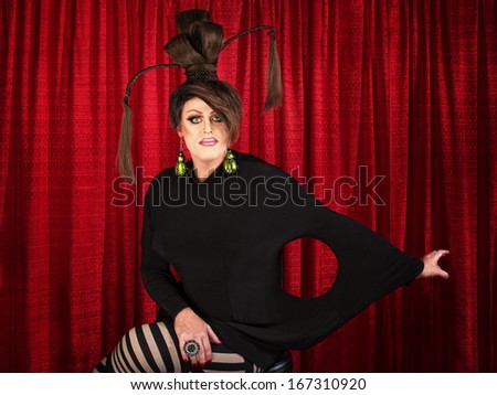 Grinning man in drag with unique dress and ponytails