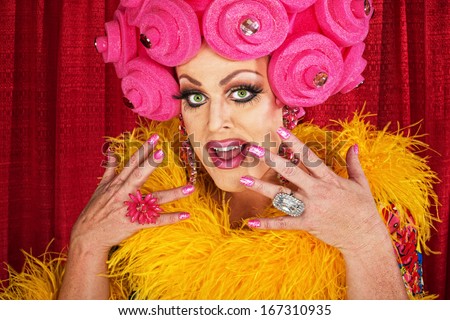 Excited white male drag queen in yellow boa