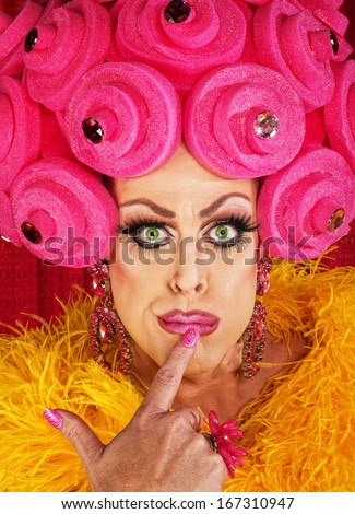 Serious cross dressing man with finger on lips