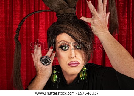 Big drag queen in theater fixing his hair