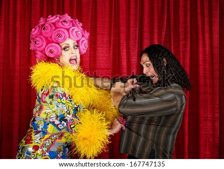 Excited drag queen in boa pulling on a man