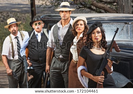 Female criminal with group of gangsters outdoors