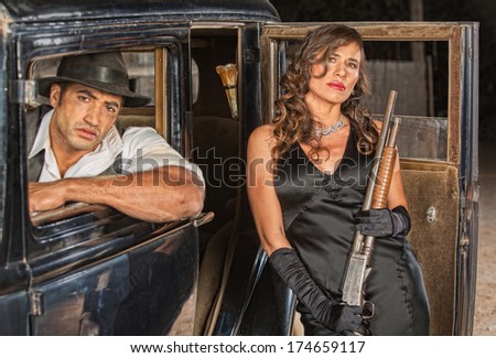Tough male and female gangsters with shotgun in car