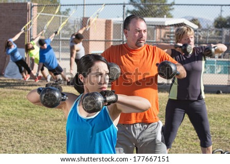 Men and women in boot camp fitness class outdoors