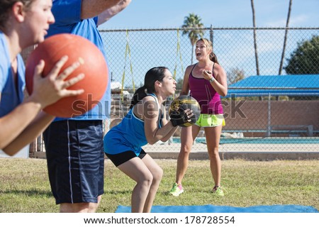 Bootcamp fitness instructor training adults with medicine ball