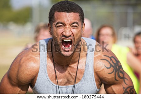 Screaming muscular fitness instructor flexing muscles