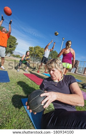 Diverse boot camp fitness class exercising outdoors