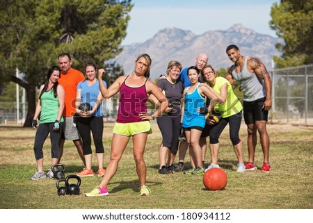 Serious female fitness instructor pointing to group of students