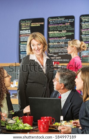 Happy customers and restaurant owner with laptop computer