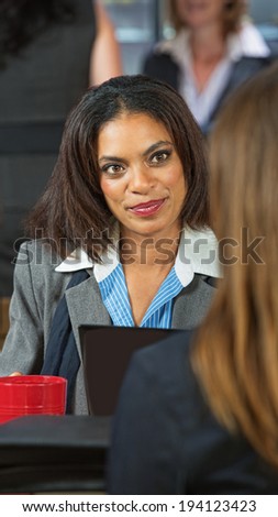 Happy business woman talking with friend in cafe