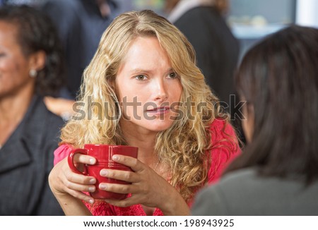 Concerned young woman talking with friend in cafe