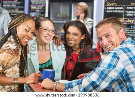 Diverse group of friends smiling in coffee house